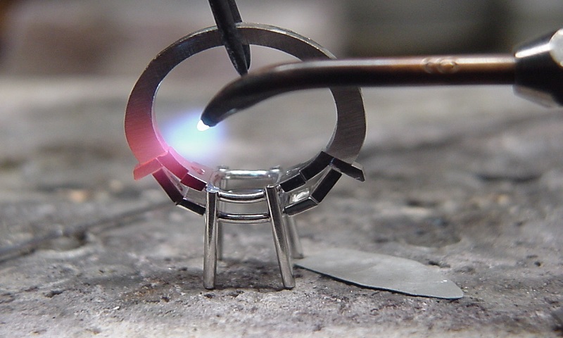 Jeweler soldering a ring setting