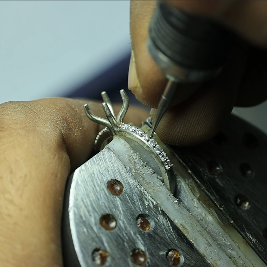 Jeweler setting diamonds in ring